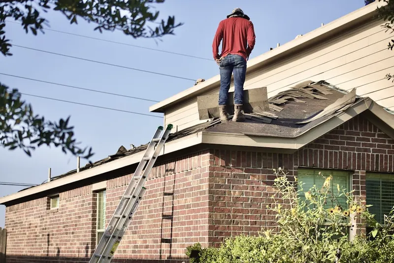 Professional roofer working on a residential roof in Ponus